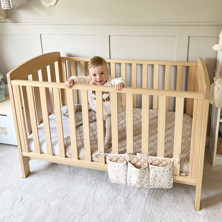 toddler inside the Almond Colored Alice cot bed