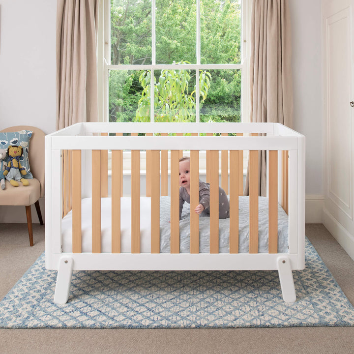 white & wooden cot bed with spindles, rounded corners and feet
