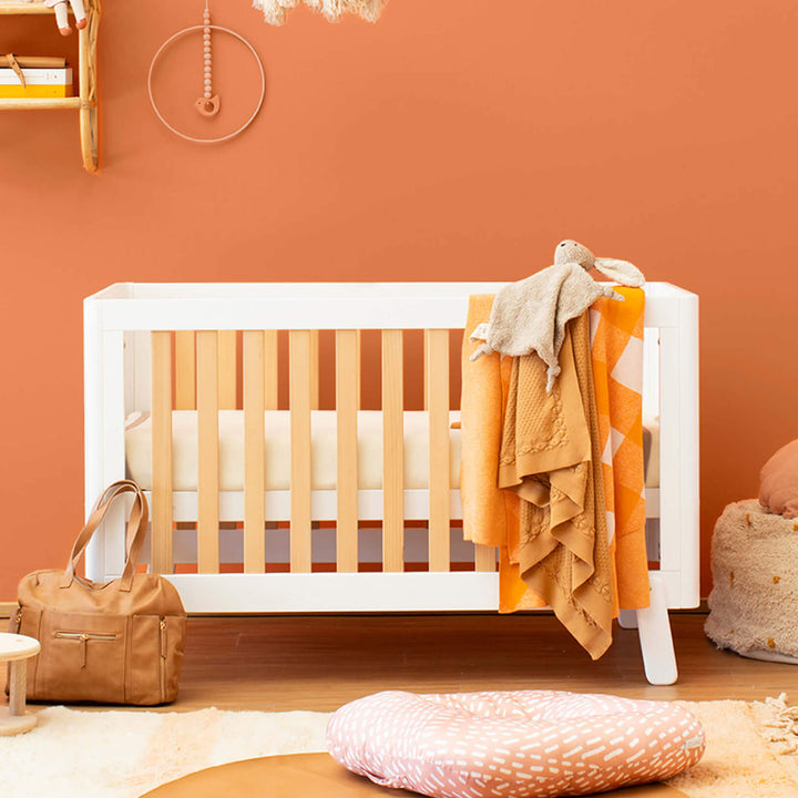 cot bed with spindles, rounded corners and feet in orange nursery