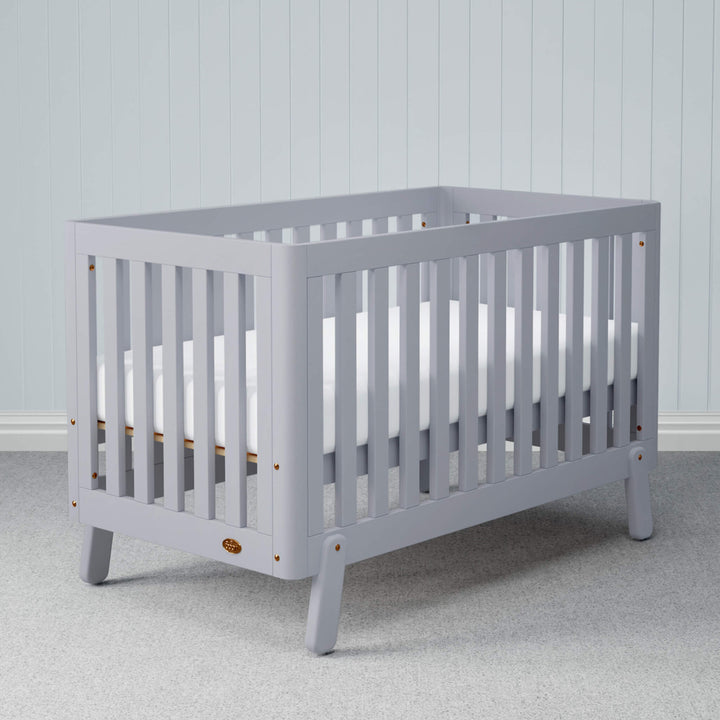 grey cot bed with spindles, rounded corners and feet