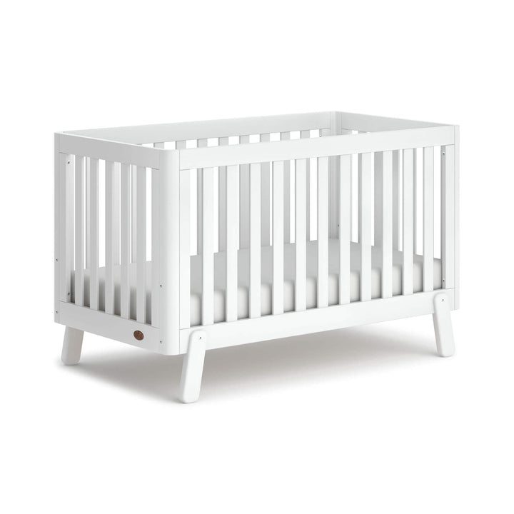 white cot bed with spindles, rounded corners and feet